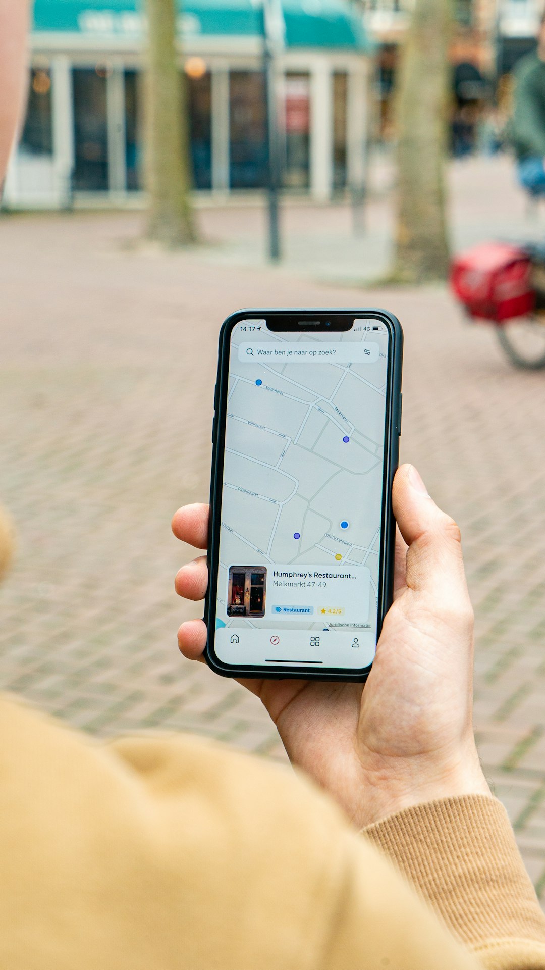 Person holding an iPhone with the CarMapr App